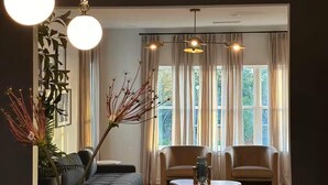 A modern living room with a sofa, chairs, a coffee table, and a decorative vase.
