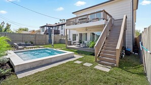 A two-story house with a balcony, a swimming pool, and a staircase leading to the upper floor.