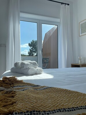 Un dormitorio con una cama grande, vistas al exterior y una pared de madera.