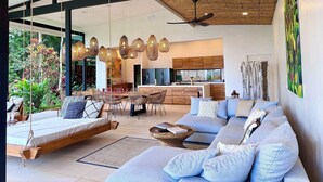 A modern interior with a suspended bed, a large sofa, a dining area, and a kitchen. - The time has come to immerse yourself in incomparable relaxation (Quesada, San Carlos)