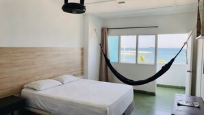 A hotel room with a bed, a hammock, a view of the sea, and a balcony. - panamerican hostel  (Santa Marta)