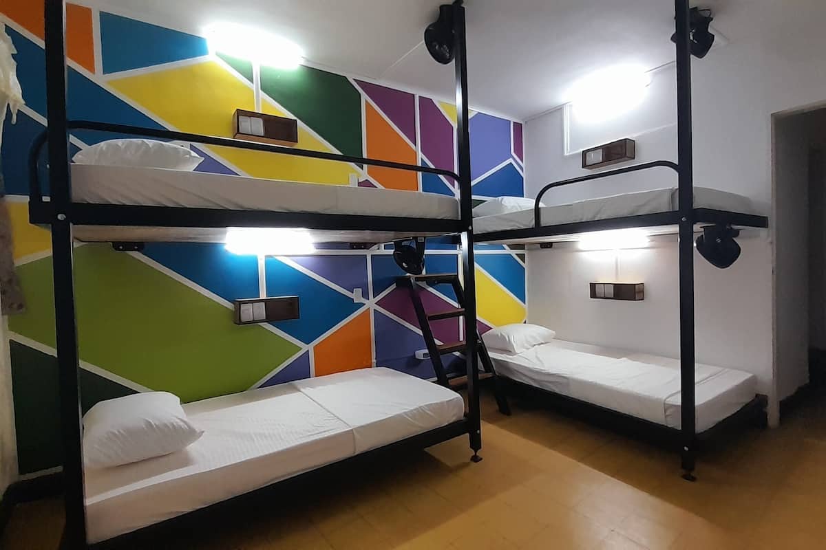 A bunk bed room with a colorful geometric wall design and built-in lighting.