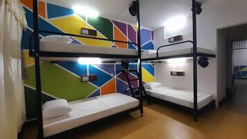 Een slaapkamer met stapelbedden, een kleurrijk geometrisch wandontwerp en ingebouwde verlichting.