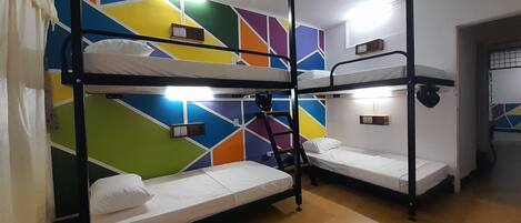 A bunk bed room with a colorful geometric wall design and built-in lighting.