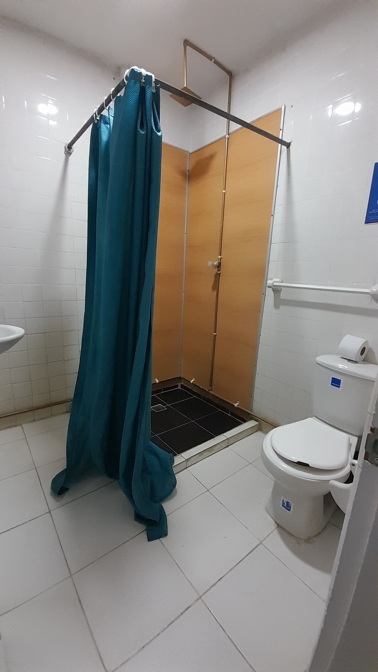Une salle de bain avec une douche, des toilettes et un lavabo.