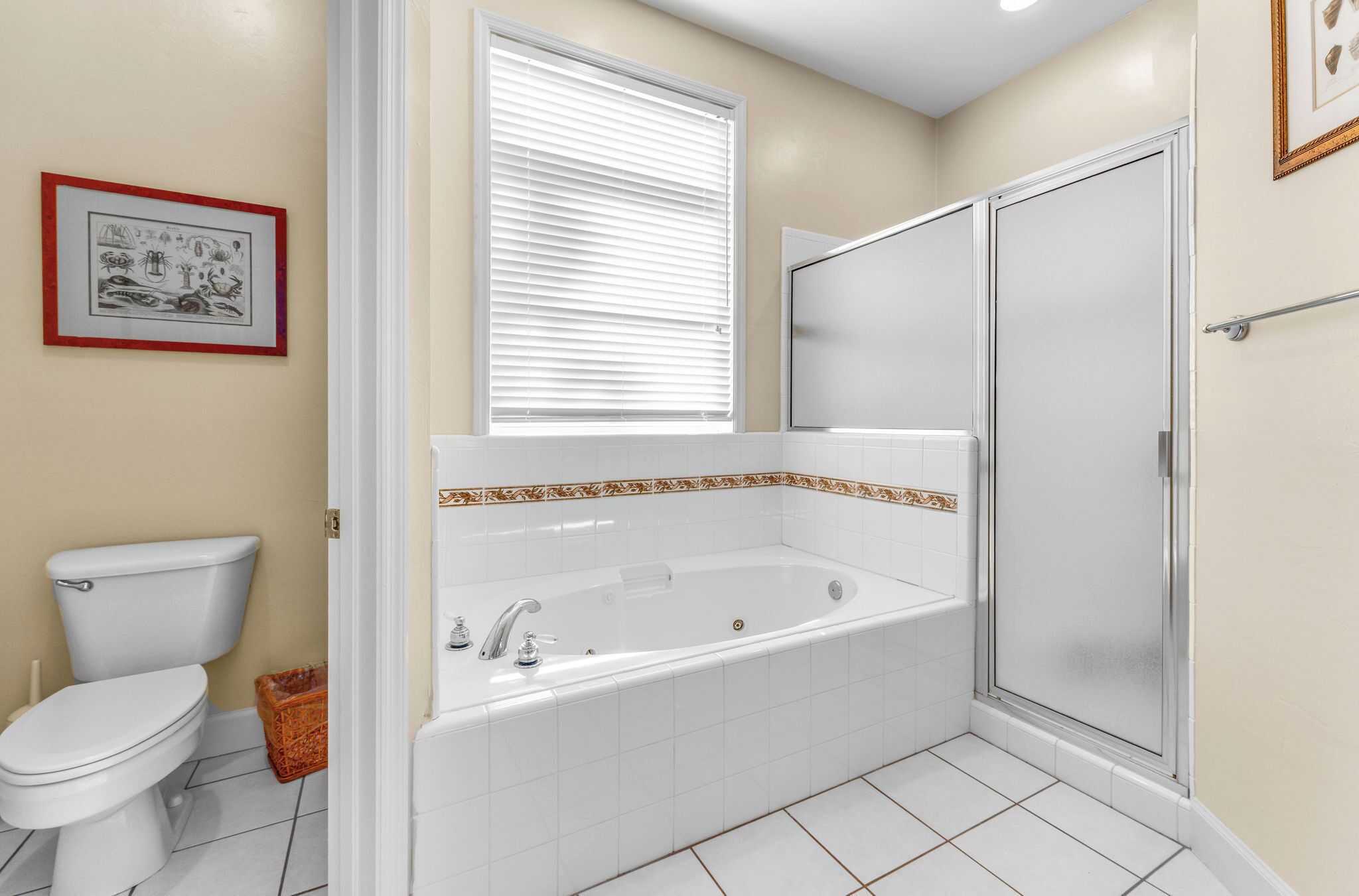A bathroom with a toilet, a bathtub, and a shower stall.