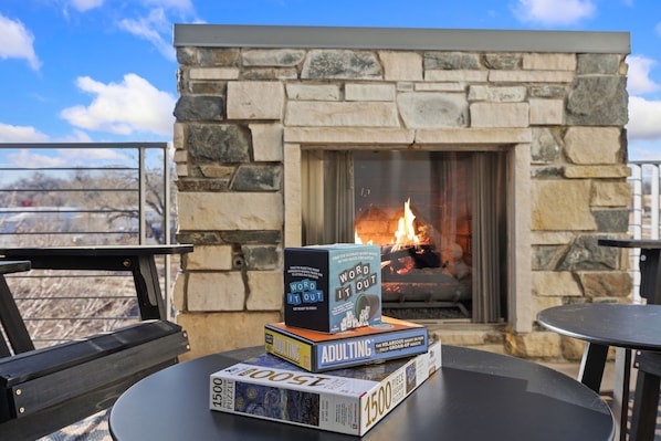 A fireplace with books stacked on a table.