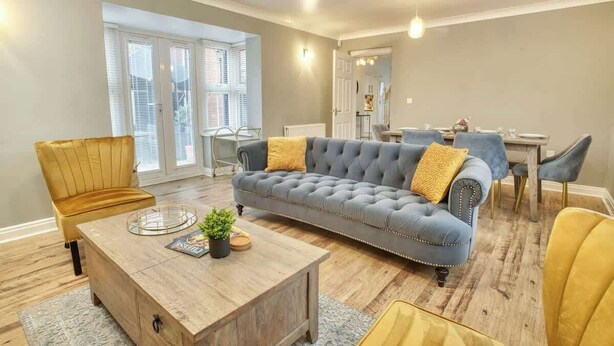 A living room with a sofa, coffee table, and chairs. - Warm & Inviting Home | Free Parking & Wi-Fi (Lincoln)