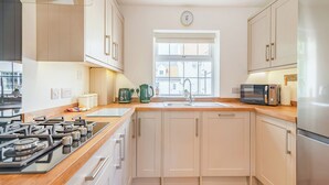 A modern kitchen with white cabinets, a stainless steel refrigerator, a microwave, and a stove. - 1 bedroom accommodation in Bempton (Bempton)