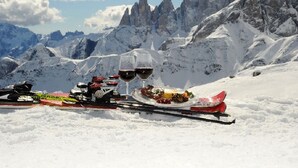A snow-covered mountain with a table set for a meal and two glasses of red wine. - Ht TEA San Pellegrino (Canale d'Agordo)