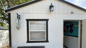 A small building with a window, a sign reading "Get Your Kicks on Route 66", and a Texas license plate. - Cozy cabin in soothing Thackerville with AC, WiFi 1 mile and 1/4 from WINN STAR. (Thackerville)