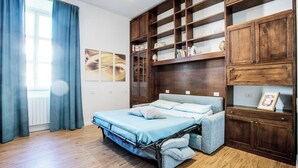 Un dormitorio con una cama, estantes de madera y una ventana con cortinas.