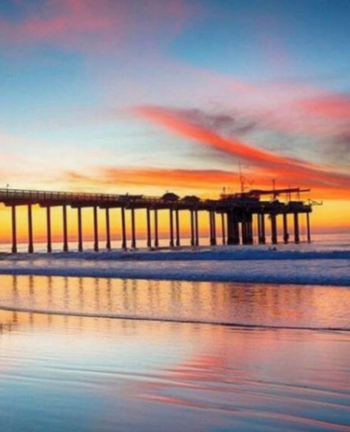 A pier extending into calm waters at sunset.