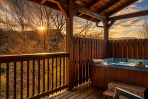 A wooden deck with a hot tub, a bench, and a view of trees and mountains. - Starwood, Hot Tub, Mtn Views, $560 In tickets each paid day (Pigeon Forge)