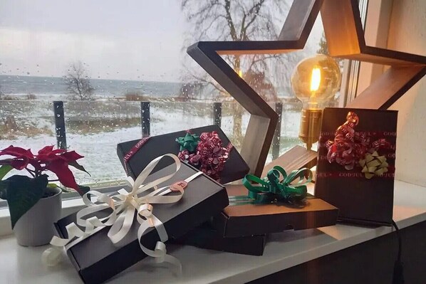 Una ventana con vista a un paisaje nevado, una planta en maceta y varias cajas de regalo con cintas.