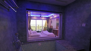 Ein modernes Badezimmer mit einem großen Spiegel, einer Badewanne und Blick auf einen Balkon.