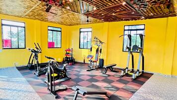 Une salle de sport équipée de matériel d’exercice, dotée de grandes fenêtres et d’un sol à motifs.