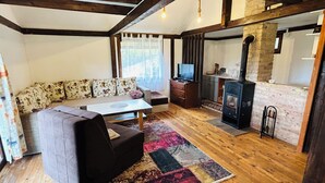 Una sala de estar acogedora con un sofá, una mesita de centro, un televisor y una chimenea.
