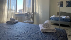 Een hotelkamer met een bed, een stoel en een kledingkast.