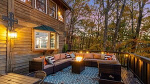 Une terrasse en bois avec un canapé, des chaises et une table.
