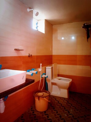 A bathroom with a bathtub, toilet, and sink. - SEA SPRAY RESORT (Kumta)