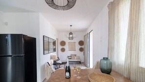 A modern kitchen with a black refrigerator, wooden table, and a woven basket. - Villa Olive & Champagne con piscina privata (Santa Maria del Focallo)