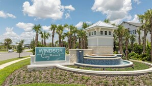 A sign for the Windsor Cay Resort with a pool area featuring a water feature. - Modern Paradise at Windsor Cay, pool and Game Room (Clermont)