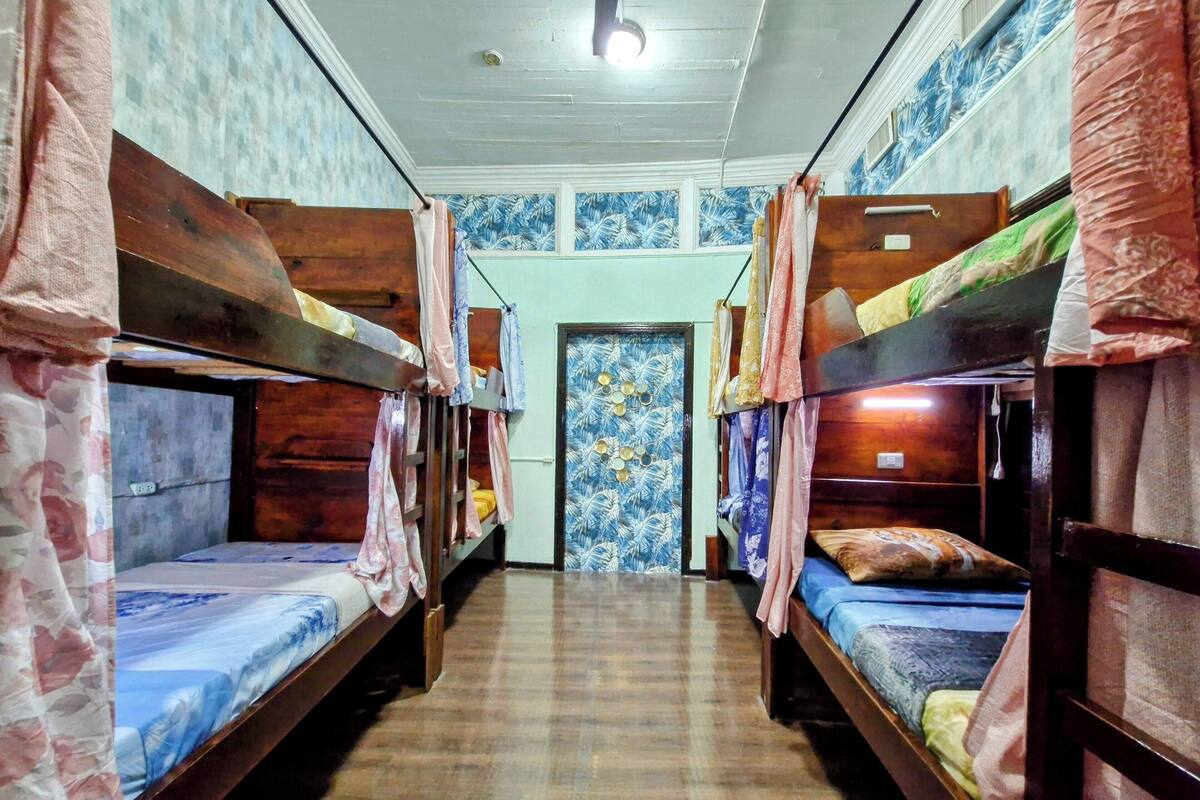 Una habitación con literas, paredes de madera y una puerta con diseño.