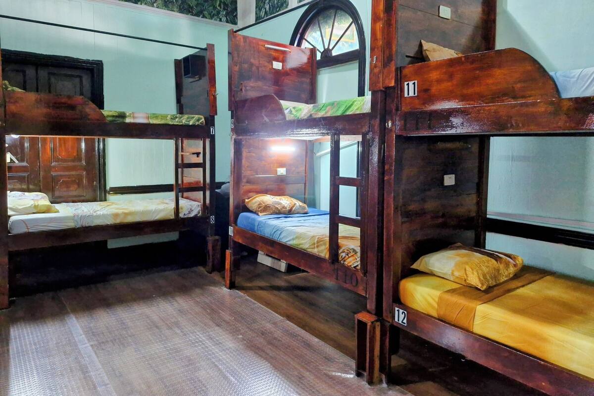 Camas literas en una habitación con ventana y puerta.