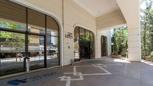A hotel entrance with large glass doors, a sign reading '1005', and a tiled floor with directional arrows. - Elegance Suítes Vila Olímpia (Sao Paulo)