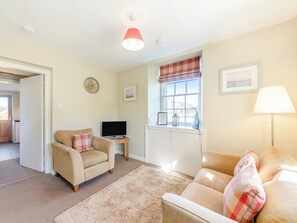 A living room with a sofa, armchair, TV, and a window with a view. - South Lodge - UK48318 (Berwick-Upon-Tweed)