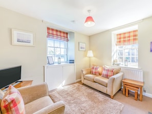 A living room with a sofa, a small table, a TV, and a window with a view. - South Lodge - UK48318 (Berwick-Upon-Tweed)