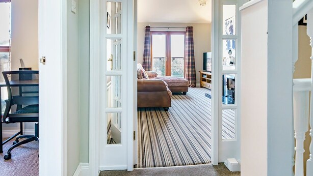 A hotel room with a large bed, a desk, and a view of the outdoors. - Beautiful 3-Bed Riverside Townhouse with Parking - Pass the Keys (Belfast)