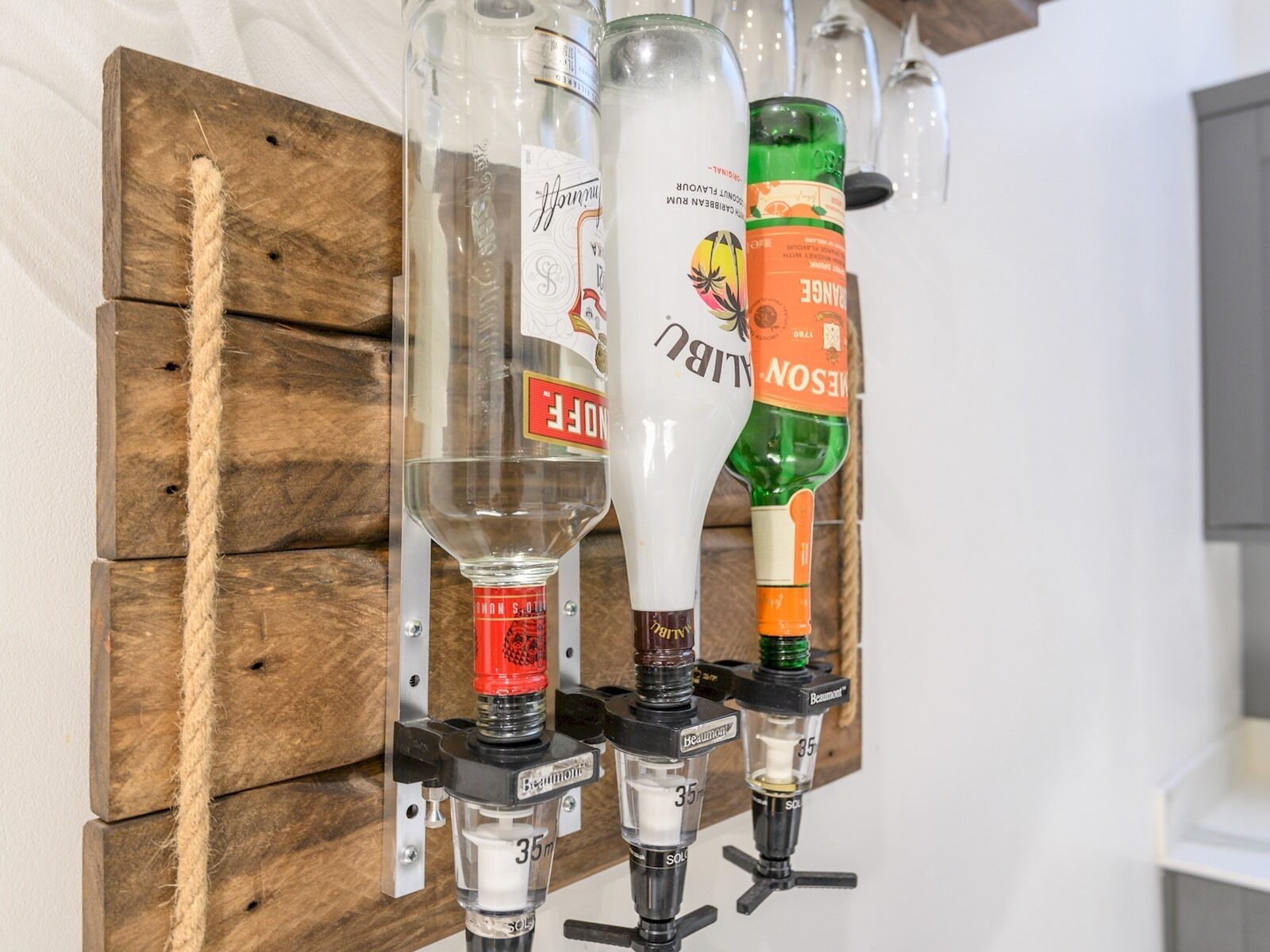 Een baropstelling met verschillende drankflessen en een houten achtergrond.