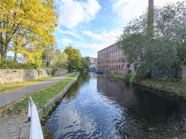 A canal with a stone wall on one side and a brick building on the other.