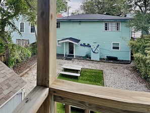 A light blue house with a small porch and a sign that reads "Gates of Joy."