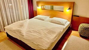 A neatly made bed with white linens in a hotel room. - Whirlpool Suite Amadeus for an Unforgettable Holiday (Bad Waltersdorf)