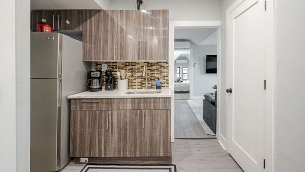 A compact kitchen with a refrigerator, coffee maker, and a tiled backsplash. - 2 Bed Apt in BlackRock by beach (Bridgeport)