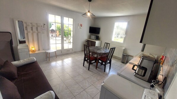 A compact living space with a dining area, kitchenette, and a large window providing natural light. - L'Ecrin is a 3-star furnished tourist accommodation. (La Bâtie-Neuve)
