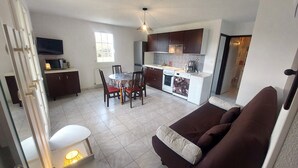 A compact living space with a kitchenette, dining area, and a sofa.
