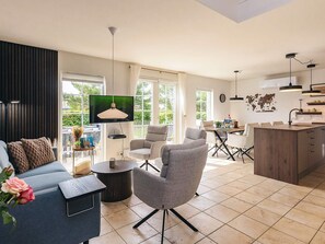 A modern living room with a sofa, chairs, a coffee table, and a TV. - 5 Star Holiday Home in Brenderup Fyn (Middelfart)