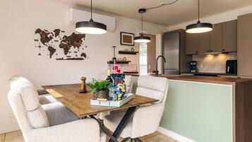 A modern kitchen with a central island, pendant lighting, and a world map wall decoration.