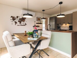 A modern kitchen with a central island, pendant lighting, and a world map wall decoration. - 5 Star Holiday Home in Brenderup Fyn (Middelfart)