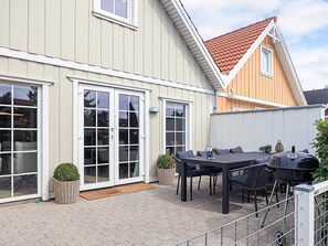 A house with a patio area featuring a table and chairs, a grill, and potted plants. - 5 Star Holiday Home in Brenderup Fyn (Middelfart)