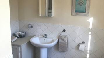 Een douche, handdoeken, zeep, shampoo