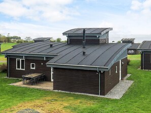 A modern house with a flat roof, a covered patio, and a view of the water. - Well-maintained Holiday Home in Faborg (Faaborg)