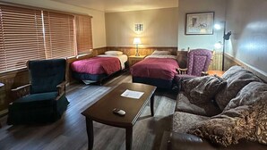 A cozy room with two beds, a chair, a table, and a lamp. - Woodland Retreat next to the Mississippi River (Alma)