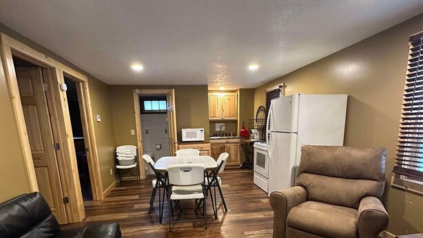 Un espacio habitable amplio con una mesa de comedor, un sofá y un sillón reclinable.