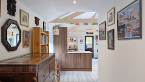 Ein geräumiger Flur mit Holzausbau, einem großen Spiegel und einer Küchenzeile mit einer Holzinsel.