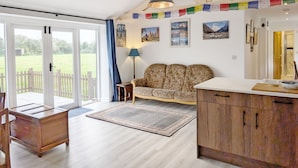 Ein geräumiges Zimmer mit einer Sitzecke, einem Esstisch und einer Küchenzeile.
